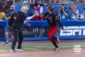Nebraska Cornhusker head coach Rhonda Revelle gives Nebraska Cornhusker Hannah Camenzind (9) after hitting a home run against the Alabama Crimson Tide in the fourth inning during the WCWS second round on Saturday, May 30, 2026, in Oklahoma City. Photo by John S. Peterson.