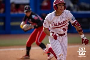 Alabama Crimson Tide Salen Hawkins (47) runs to first as Nebraska Cornhusker utility Samantha Bland (29) throws to first for an out in the first inning during the WCWS second round on Saturday, May 30, 2026, in Oklahoma City. Photo by John S. Peterson.