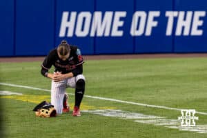 Nebraska Cornhusker outfielder Hannah Coor (23) takes a knee before the game against the Arkansas Razorbacks during the WCWS first round on Thursday, May 28, 2026, in Oklahoma City. Photo by John S. Peterson.