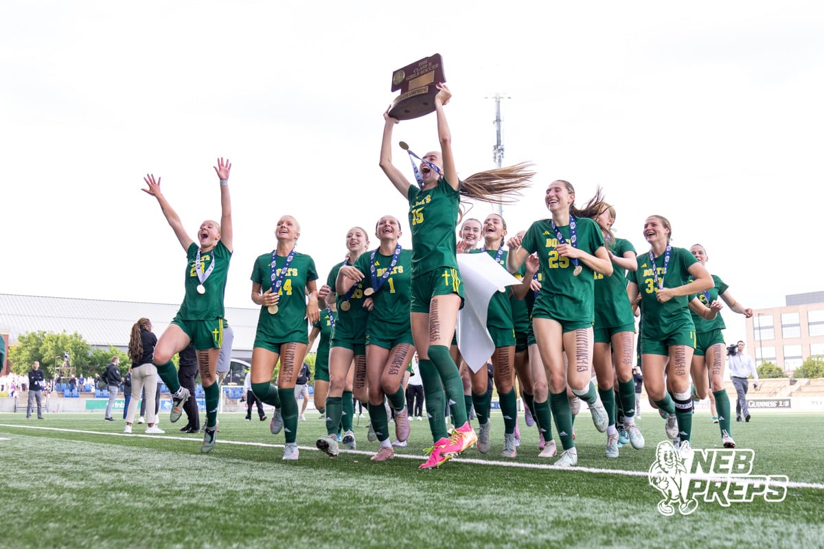 12_JRS20260519_GSOC_B_PIUS_v_BHS_014_WM Lincoln Pius X’s Haley Thomsen (15) is raising up the NSAA Class B State Championship trophy while running to the crowd with her team behind her after winning the NSAA Class B Girls State Championship game against Blair on Tuesday, May 19, 2026 in Omaha, Nebraska. Photo By Jack Stephens