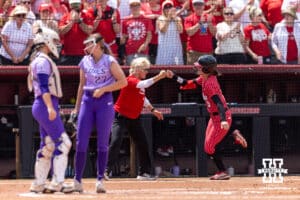 Nebraska Cornhusker Hannah Camenzind (9) receives a fist bump from head coach Rhonda Revelle running the bases after hitting a home run in the first inning during the NCAA Softball Regionals on Sunday, May 17, 2026, in Lincoln, Neb. Photo by John S. Peterson.