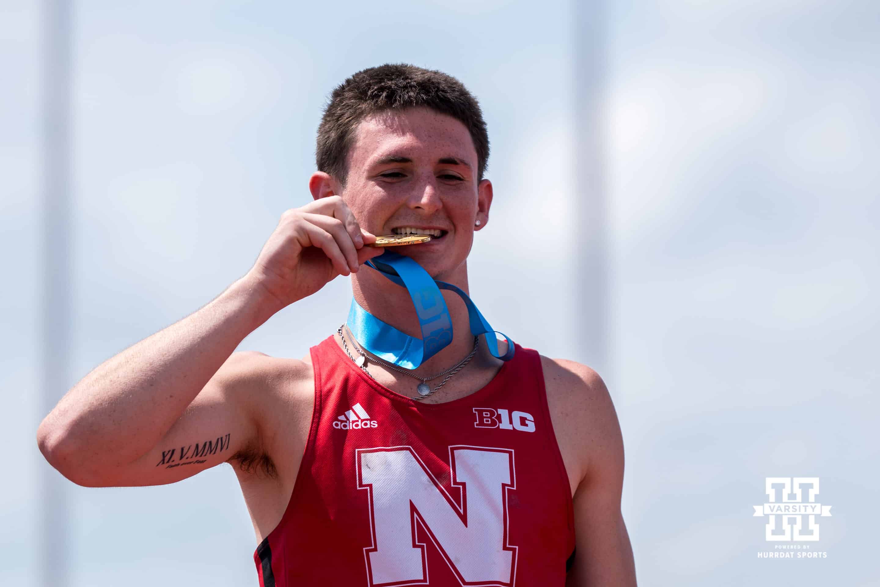 Nebraska Cornhusker Dyson Wicker bites his medal during the Big Ten OTF Championships on May 17, 2026, in Lincoln, Nebraska. Photo by Brandon Tiedemann.