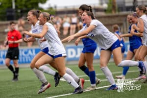 Omaha Marian’s Mya Sennett (17) is celebrating with her teammates after scoring a goal against Kearney during semi-finals of the NSAA State Soccer Championships on Friday, May 15, 2026, in Omaha, Nebraska. Photo By Jack Stephens.