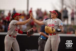 Nebraska Cornhusker infielder Bella Bacon (3) gets a high five from Samantha Bland after getting the last out to during the first round of the NCAA Softball Regionals on Friday, May 15, 2026, in Lincoln, Neb. Photo by John S. Peterson.