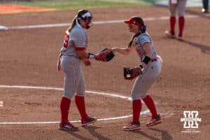 Nebraska Cornhusker infielder Ava Kuszak (7) hands the ball to pitcher Alexis Jensen in the second inning against the South Dakota Coyotes during the first round of the NCAA Softball Regionals on Friday, May 15, 2026, in Lincoln, Neb. Photo by John S. Peterson.