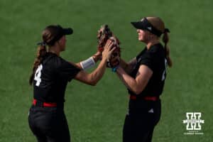 South Dakota Coyote infielders Autumn Iversen (4) and Brooke Carey (20) give each other high fives before taking on the Nebraska Cornhuskers during the first round of the NCAA Softball Regionals on Friday, May 15, 2026, in Lincoln, Neb. Photo by John S. Peterson.