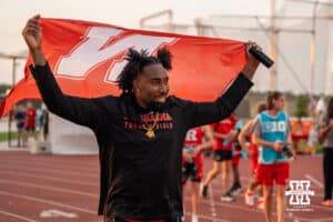 Nebraska Cornhusker walks around with the Nebraska flag during the Big Ten OTF Championships on May 15, 2026, in Lincoln, Nebraska. Photo by Brandon Tiedemann.