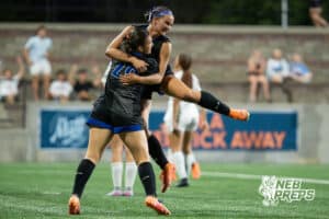 Omaha Marian's Cleo Washington (7) celebrates a goal with Leena Brunt (20) during the girls' Class A soccer match against Lincoln Southeast on Monday, May 11, 2026, in Omaha, Nebraska. Photo by Jackson D. Luethje.