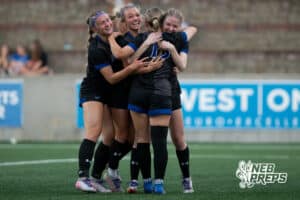 Omaha Marian's Skylar Farley (13) celebrates goal with Bristol Povondra (8),Emmy Boyle (2), and Zoey Ridder (9) during the girls' Class A soccer match against Lincoln Southeast on Monday, May 11, 2026, in Omaha, Nebraska. Photo by Jackson D. Luethje.