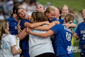 Kearney mobs the head coach, Lerrin Rowe, after the win during the girls' Class A soccer match against Millard South on Monday, May 11, 2026, in Omaha, Nebraska. Photo by Jackson D. Luethje.