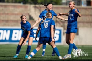 Kearney's Addie Snyder (18), Molli Kalsbeck (10), Hallie Garner (14), and Alyssa Hoffart (9) celebrate a goal during the girls' Class A quarter-final soccer match against Millard South on Monday, May 11, 2026, in Omaha, Nebraska. Photo by Jackson D. Luethje.