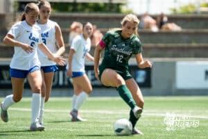 Lincoln Southwest's Peyton Held (12) dribbles the ball while being defended by Lincoln East's Brynn Hershberger (6) during the girls Class A quarter-final soccer match on Monday, May 11, 2026, in Omaha, Nebraska. Photo by Jackson D. Luethje.