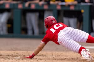 Nebraska Cornhusker Drew Grego (10) scores a run reaching for home plate from Jett Buck sac-fly in the seventh during a college baseball game on Saturday, May 9, 2026, in Lincoln, Neb. Photo by John S. Peterson.