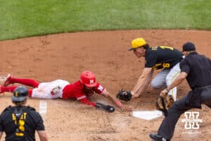 Nebraska Cornhusker Jeter Worthley (0) scores a run on a wild pitch against Iowa Hawkeye pitcher Brady Ferguson (16) trying to tag him in the fourth inning during a college baseball game on Saturday, May 9, 2026, in Lincoln, Neb. Photo by John S. Peterson.
