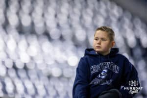Creighton fan looks into the crowd while sitting on the ledge of a fence during a college baseball game against the Kansas Jayhawks on Tuesday, May 5, 2026, in Omaha, Nebraska. Photo by Braden Cochran.
