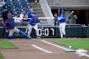 A Creighton batter drops his bat at home plate while watching the ball slide down the base line towards first base during a college baseball game against the Kansas Jayhawks on Tuesday, May 5, 2026, in Omaha, Nebraska. Photo by Braden Cochran.