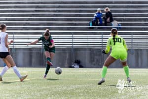 Lincoln Southwest Ansley Throener (9) scores a goal against Columbus Odalys Molina-Aguilar (00), tying the season record for goals during a high school soccer match on Wednesday, May 6, 2026, in Lincoln, Neb. Photo by John S. Peterson.