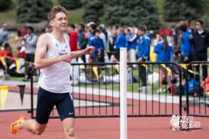 Zander Carson-Koestner smiles as he crosses the finish line during the Metro Conference T&F Meet on May 6, 2026, in Omaha, Nebraska. Photo by Brandon Tiedemann.