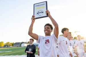 Roncalli’s Jordan Martinez (21) is raising the championship plaque in the air after winning the River Cities Conference Championship against South Sioux City on Thursday, April 30, 2026 in South Sioux City, Nebraska. Photo by Jack Stephens.