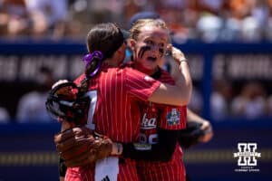 Nebraska Cornhusker pitcher Jordy Frahm (98) gives Ava Kuszak a hug after making the last out in the three inning against the Texas Longhorns during the WCWS elimination game on Sunday, May 31, 2026, in Oklahoma City. Photo by John S. Peterson.