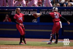 Nebraska Cornhusker starting pitcher Jordy Frahm (98) and catcher Jesse Farrell (25) tap gloves after the first inning during the WCWS elimination game on Sunday, May 31, 2026, in Oklahoma City. Photo by John S. Peterson.