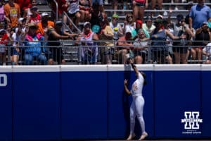 Texas Longhorn outfielder Kayden Henry (21) reaches for the ball as it goes over the wall in the first inning against the Nebraska Cornhuskers during the WCWS elimination game on Sunday, May 31, 2026, in Oklahoma City. Photo by John S. Peterson.
