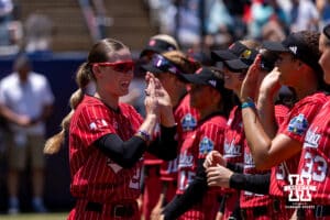Nebraska Cornhusker outfielder Hannah Coor (23) gives high-fives to teammates against the Texas Longhorns during the WCWS elimination game on Sunday, May 31, 2026, in Oklahoma City. Photo by John S. Peterson.
