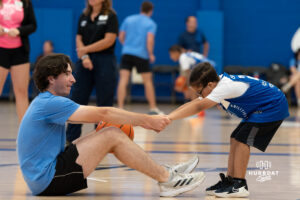A Creighton Bluejay fan helps up a worker during their yearly abilities camp on June 5, 2026, in Omaha, Nebraska. Photo by Brandon Tiedemann.