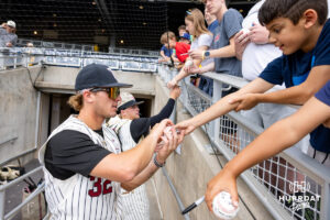 Troy Trojan 2026 infielder Josh Pyne (32) signs a baseball during the CWS media day on Thursday, June 11, 2026, in Omaha, Neb. Photo by John S. Peterson.