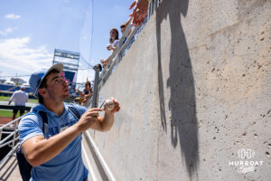 North Carolina Tar Heel signs a baseball for a fan during the CWS media day on Thursday, June 11, 2026, in Omaha, Neb. Photo by John S. Peterson.