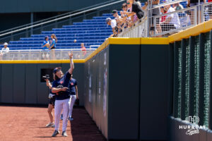 Ole Miss Rebels outfileder signs a baseball in the outfield during the CWS media day on Thursday, June 11, 2026, in Omaha, Neb. Photo by John S. Peterson.