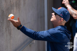 Ole Miss head coach Mike Bianco signs a baseball during the CWS media day on June 11, 2026, in Omaha, Nebraska. Photo by Brandon Tiedemann.
