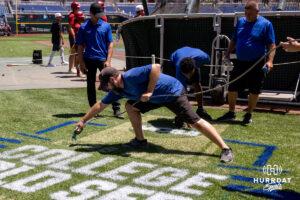 Grounds crew start the process of paing the CWS logo behind home plate during the CWS media day on Thursday, June 11, 2026, in Omaha, Neb. Photo by John S. Peterson.