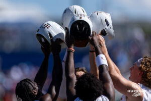 Texas Longhorns hold helmets up after practice running bases during the CWS media day on Thursday, June 11, 2026, in Omaha, Neb. Photo by John S. Peterson.