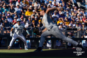 North Carolina Tar Heel Gavin Gallaher (5) leading off as West Virginia Mountaineer pitcher Maxx Yehl (15) throws a pitch in the first inning during the College World Series baseball tournament on Sunday, June 14, 2026, in Omaha, Neb. Photo by John S. Peterson.