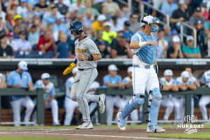 West Virginia Mountaineer infielder Ben Lumsden (24) scores on the Armani Guzman single in the third during the College World Series baseball tournament on Sunday, June 14, 2026, in Omaha, Neb. Photo by John S. Peterson.