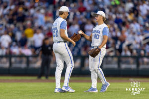 North Carolina Tar Heel pitcher Walker McDuffie (40) hands the ball over Caden Glauber (27) to relive him in the ninth inning against the West Virginia Mountaineers during the College World Series baseball tournament on Sunday, June 14, 2026, in Omaha, Neb. Photo by John S. Peterson.