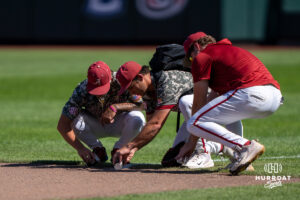 Alabama players put dirt in cups during a CWS game on June 15, 2026, in Omaha, Nebraska. Photo by Brandon Tiedemann.