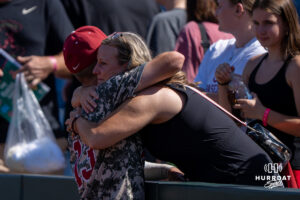 Alabamas Luke Vaughn (13) hugs a family member during a CWS game on June 15, 2026, in Omaha, Nebraska. Photo by Brandon Tiedemann.