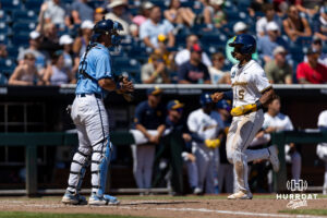 West Virginia Mountaineer utility Armani Guzman (5) scores a run against the North Carolina Tar Heels in the seventh during the College World Series baseball tournament on Wednesday, June 17, 2026, in Omaha, Neb. Photo by John S. Peterson.