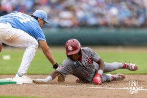 Oklahoma Sooner Jason Walk (1) dives back to first base against North Carolina Tar Heel utility Erik Paulsen (44) in the sixth inning during the Finals of the College World Series baseball tournament on Saturday, June 20, 2026, in Omaha, Neb. Photo by John S. Peterson.