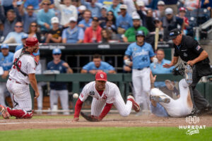 Oklahoma Sooners Xander Mercurius (23) and Deiten Lachance (48) watch as a ball gets loose during the third inning of a CWS game on June 21, 2026, in Omaha, Nebraska. Photo by Brandon Tiedemann.