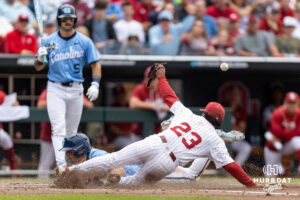 North Carolina Tar Heel infielder Jake Schaffner (2) scores on a wild pitch as the Oklahoma Sooner pitcher Xander Mercurius (23) tries to cover home during game two of the Finals of the College World Series baseball tournament on Sunday, June 21, 2026, in Omaha, Neb. Photo by John S. Peterson.