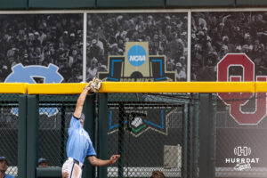 North Carolina Tar Heel outfielder Carter French (18) makes a catch at the wall against the Oklahoma Sooners in the eighth inning during game two of the Finals of the College World Series baseball tournament on Sunday, June 21, 2026, in Omaha, Neb. Photo by John S. Peterson.
