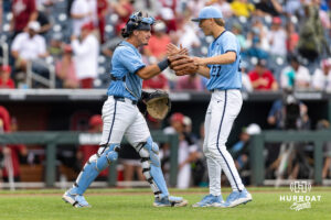North Carolina Tar Heel pitcher Caden Glauber (27) and catcher Colin Hynek (23) celebrates the win against the Oklahoma Sooners during game two of the Finals of the College World Series baseball tournament on Sunday, June 21, 2026, in Omaha, Neb. Photo by John S. Peterson.