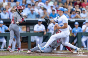 Oklahoma Sooner infielder Dayton Tockey (16) scores on a wild ptics during game three of the Finals of the College World Series baseball tournament on Monday, June 22, 2026, in Omaha, Neb. Photo by John S. Peterson.