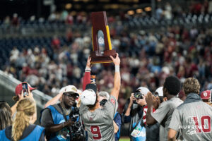 Oklahoma Sooners Camden Johnson (9) holds the trophy after a CWS game on June 22, 2026, in Omaha, Nebraska. Photo by Brandon Tiedemann.