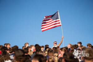 Spectators watch from the stands during a game on an outdoor field.