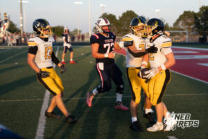 A boys football player competes during a game on an outdoor field.
