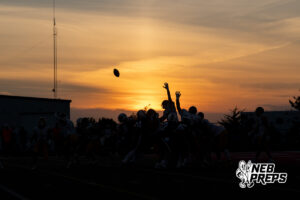 A wide view of a boys football venue shows play under way during a game on an outdoor field.